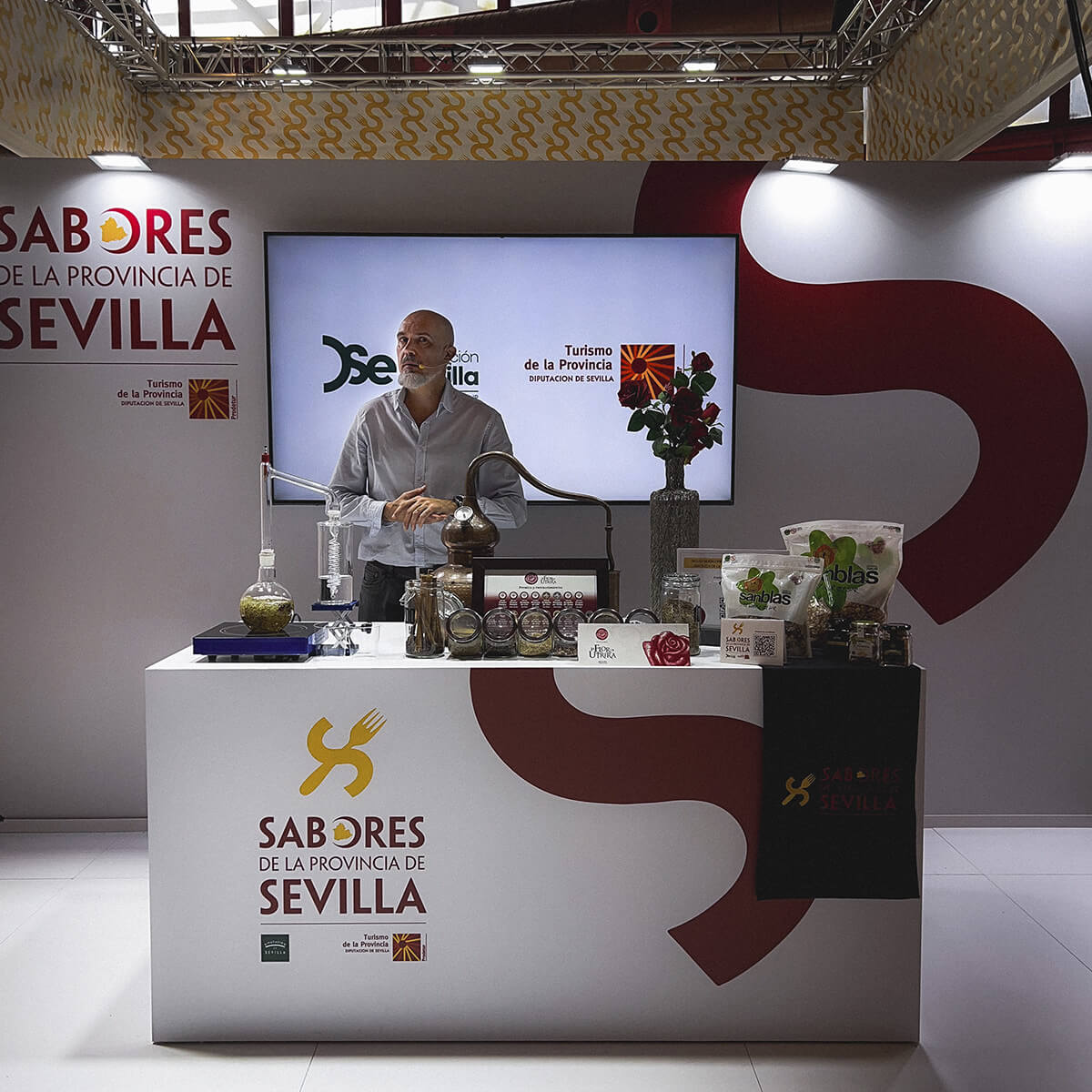 Representante de La Flor de Utrera realizando una demostración de destilación artesanal en el stand de Sabores de la Provincia de Sevilla durante el Salón H&T Málaga 2025.