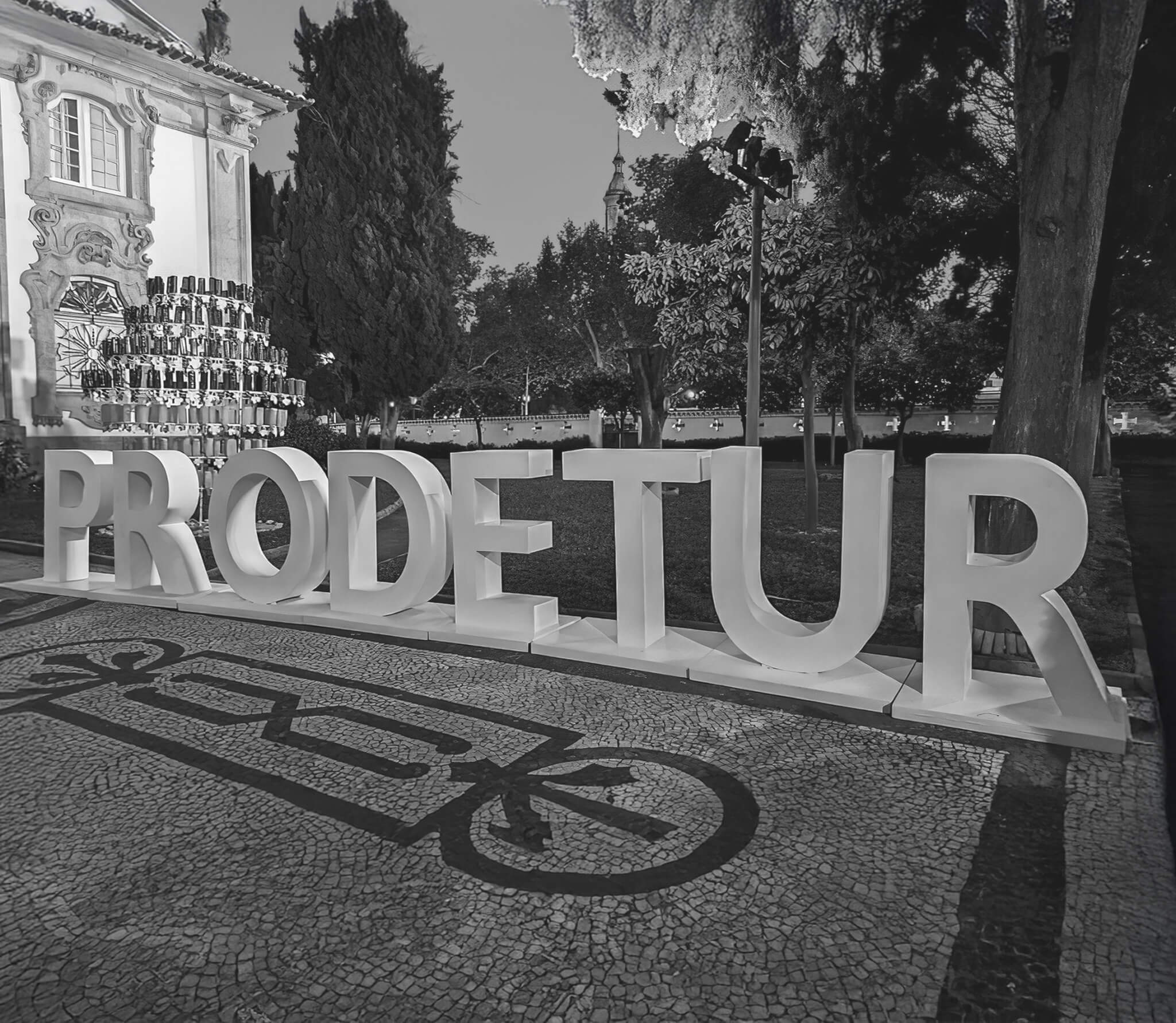 Estructura de letras gigantes formando la palabra PRODETUR durante la Feria de la Provincia de Sevilla 2024, en un entorno ajardinado